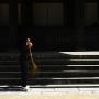 A Buddhist monk sweeps off temple stairs. Photo by JL, (c) ASC