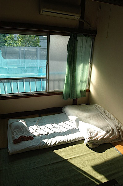 A futon bed on tatami mats in a typical Japanese bedroom. Photo by JL, (c) ASC